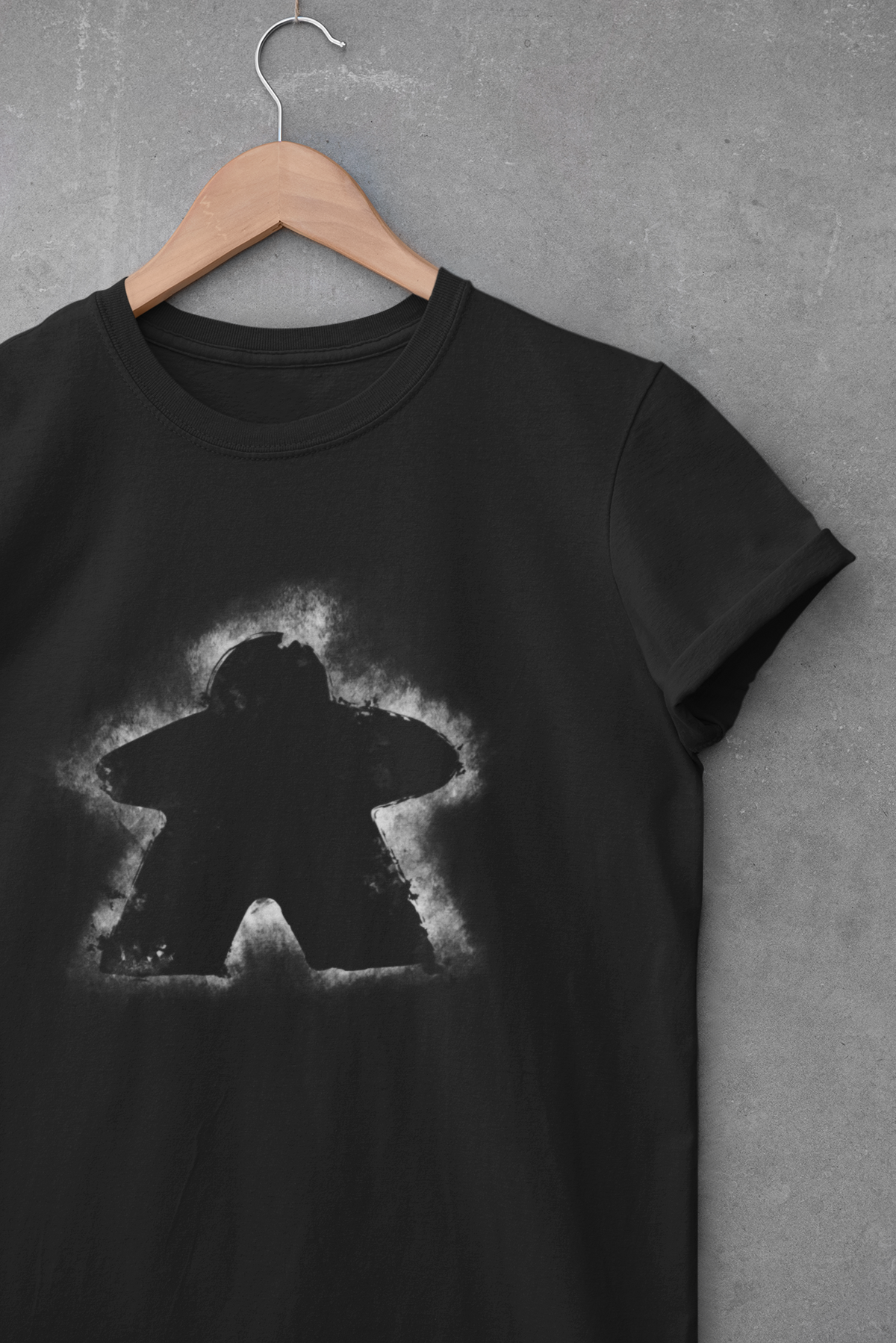 Black t-shirt with a white graphic of a meeple on a gray background