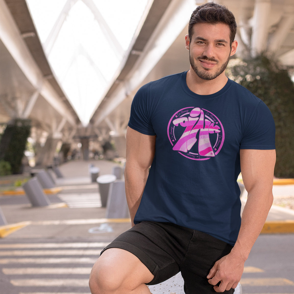 Man wearing a navy blue t-shirt with our I'm Always Pink Meeple design in an outdoor setting