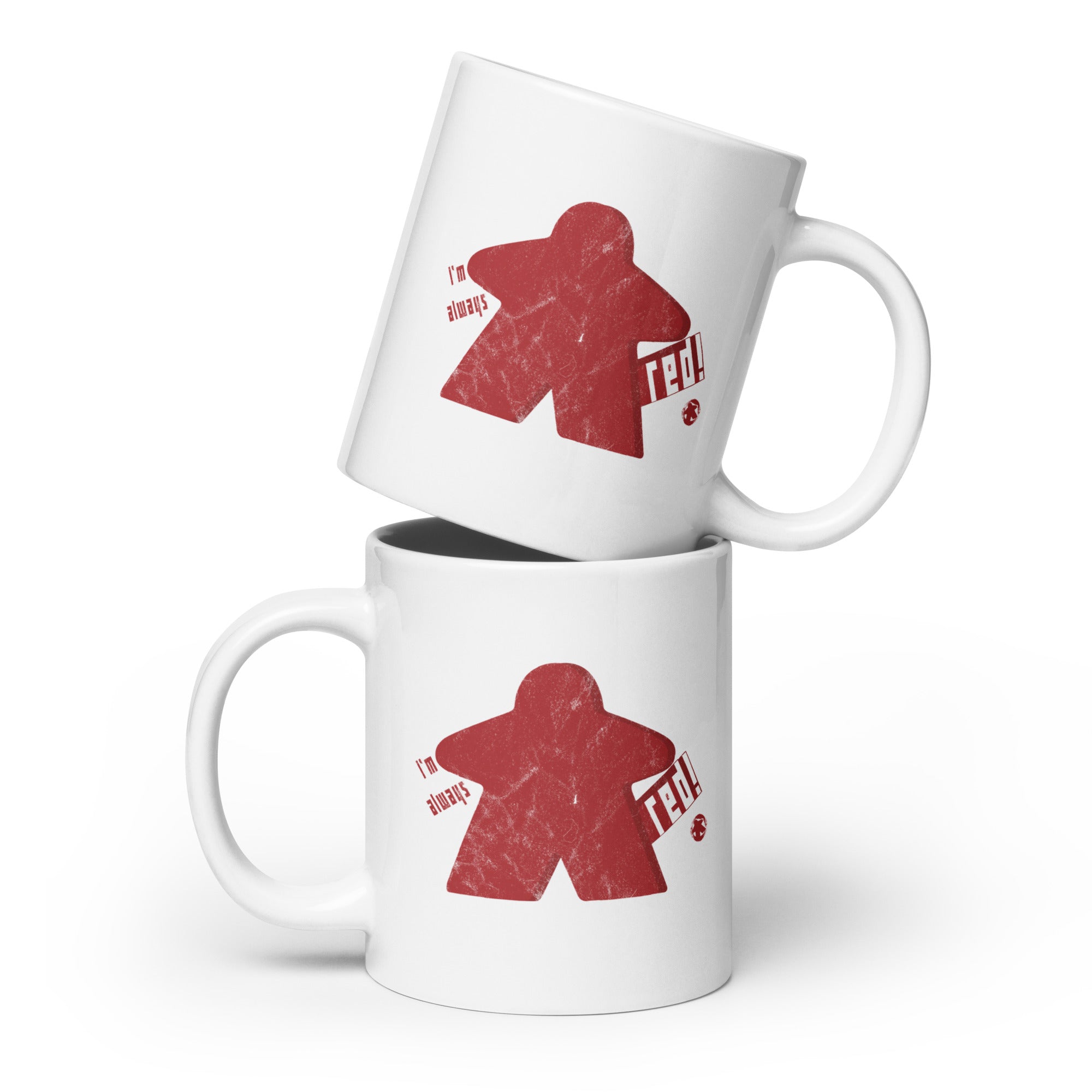 A stacked set of white ceramic coffee mugs with our I'm Always Red Meeple design
