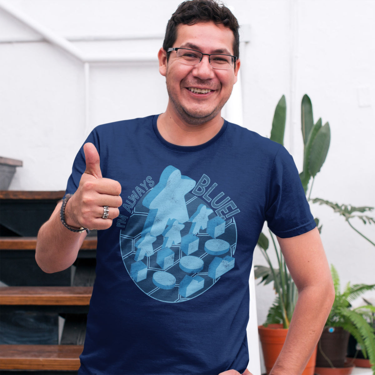 Man wearing a navy blue t-shirt with our i'm always blue design, giving a thumbs-up gesture.