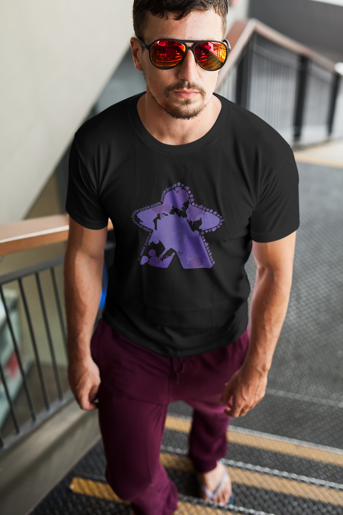 Man wearing a black t-shirt with our I'm Always Purple design, standing on a staircase.