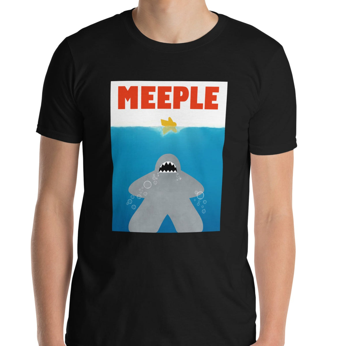 Model wearing black t-shirt with our meeple shark attack design printed on it