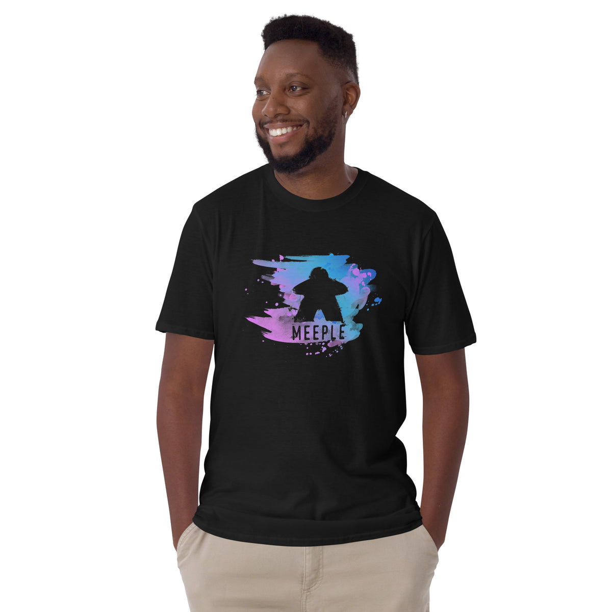 Man standing against a white background wearing a black t-shirt with our meeple splash design printed on it.