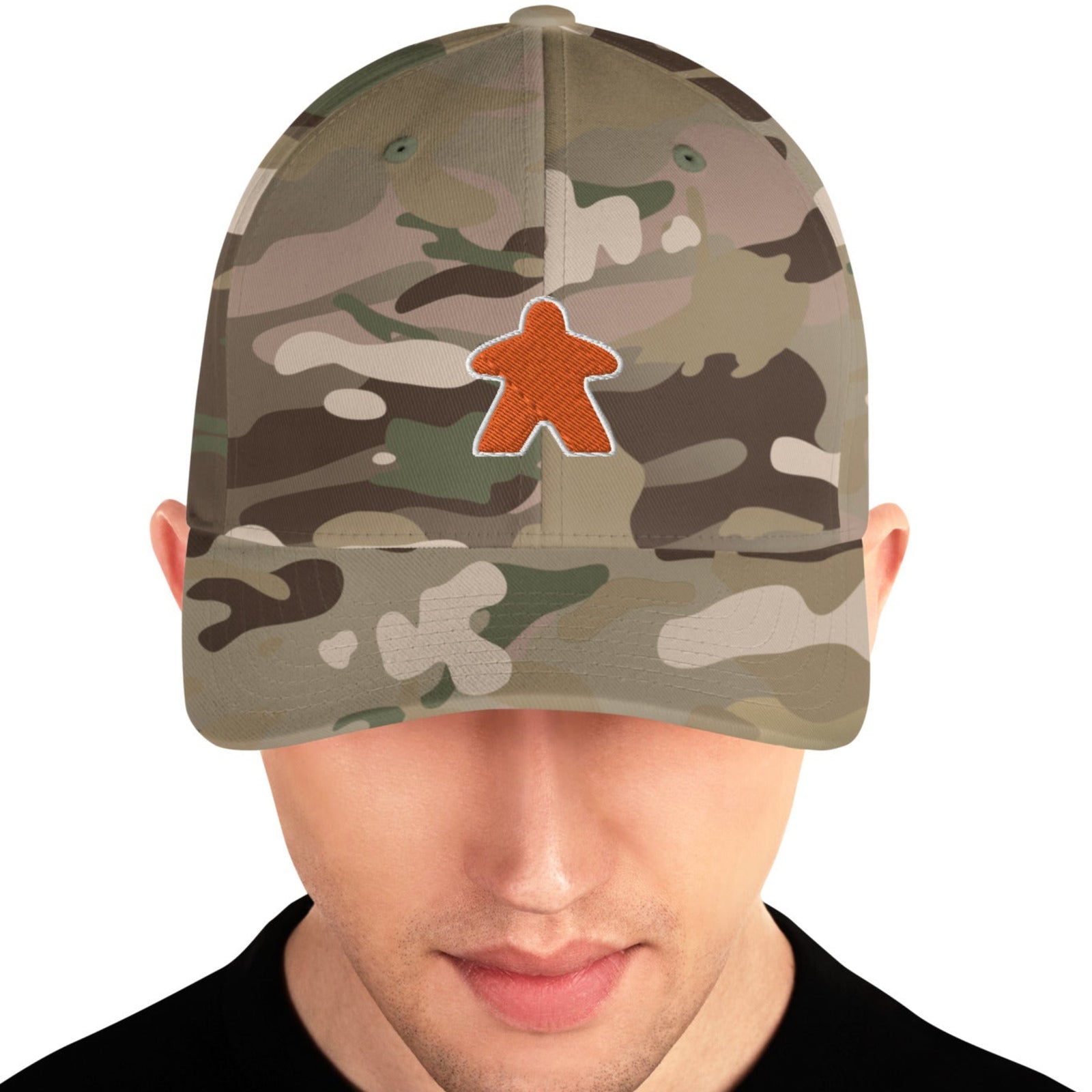 Camo hat worn by a man with an embroidered orange meeple on the front