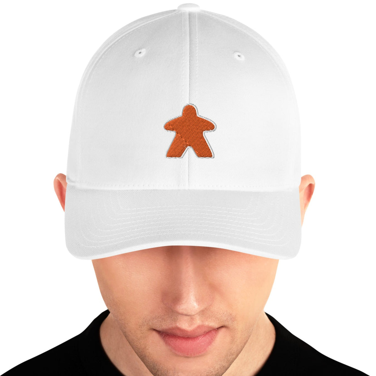 White hat worn by a man with an embroidered orange meeple on the front