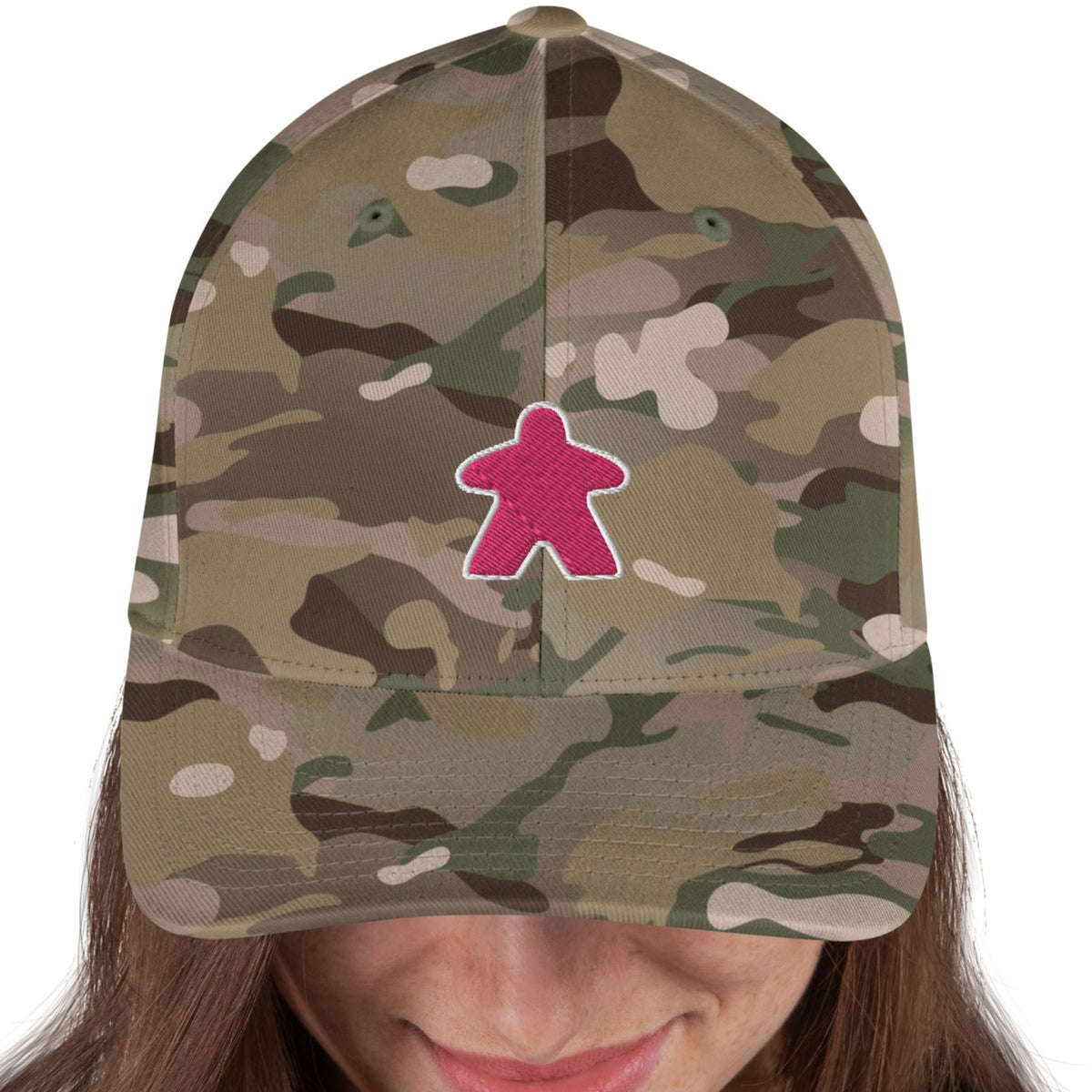 Model wearing a camo hat with our pink meeple design embroidered on the front