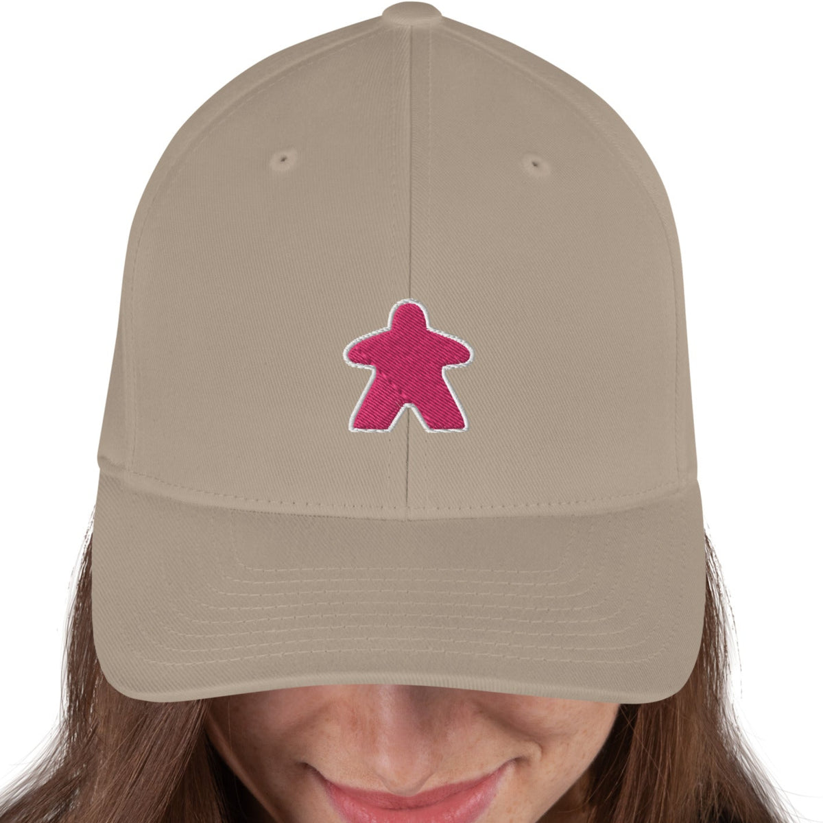 Tan flexfit board game hat with our pink meeple design embroidered on the front