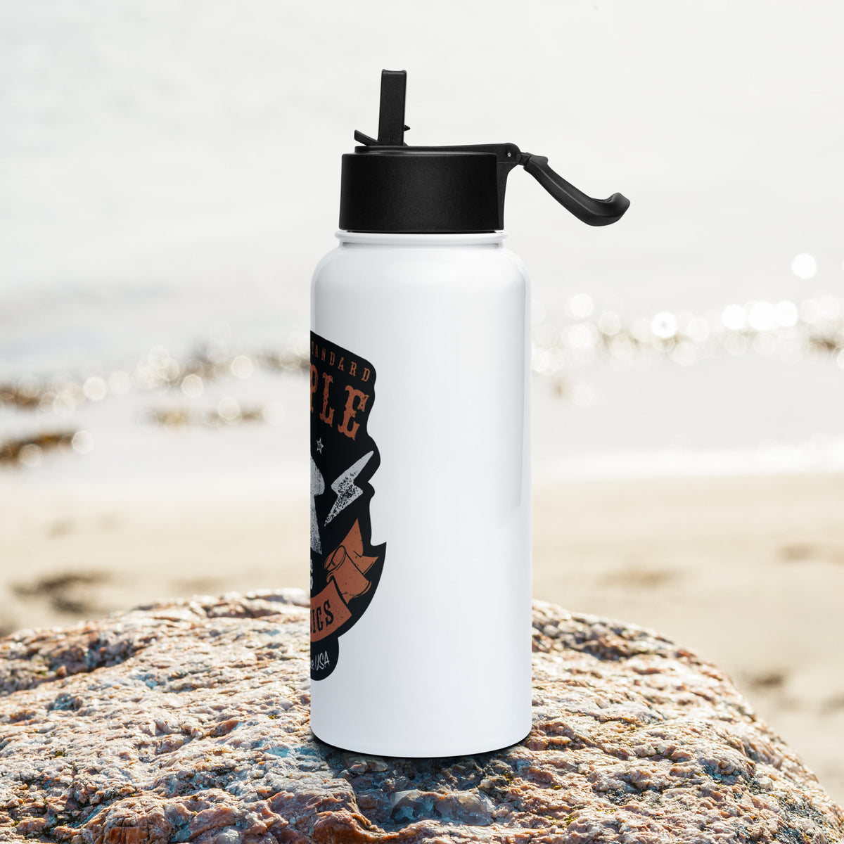 American Meeple Classics design on water bottle positioned on a rock at the beach - Side Shot