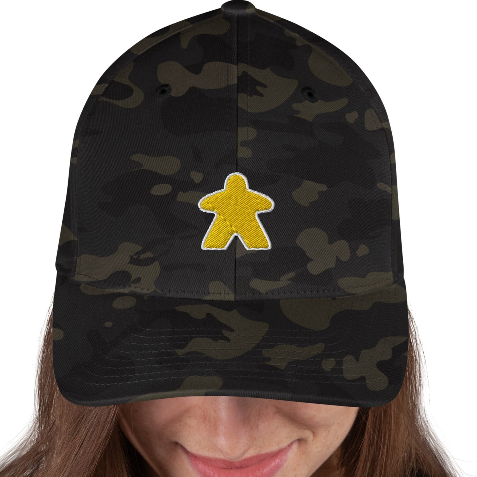 A black camouflage hat with a yellow meeple (game piece) embroidered on the front.